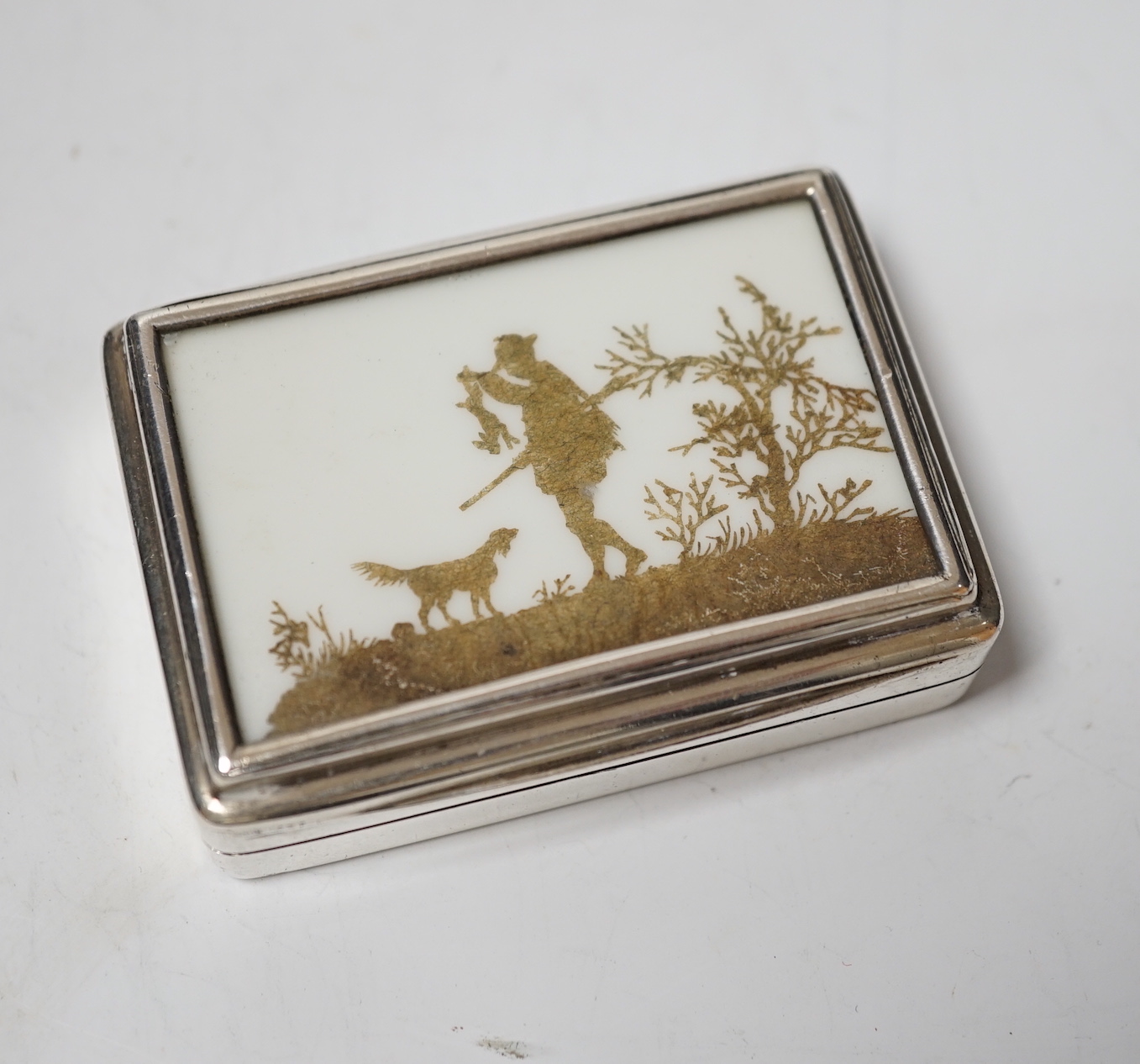 An Edwardian silver twin compartment stamp case, the cover with unusual silhouette scene using brown cut paper, depicting a hunter with his dog, Colen Hewer Cheshire, Chester, 1907, 63mm.